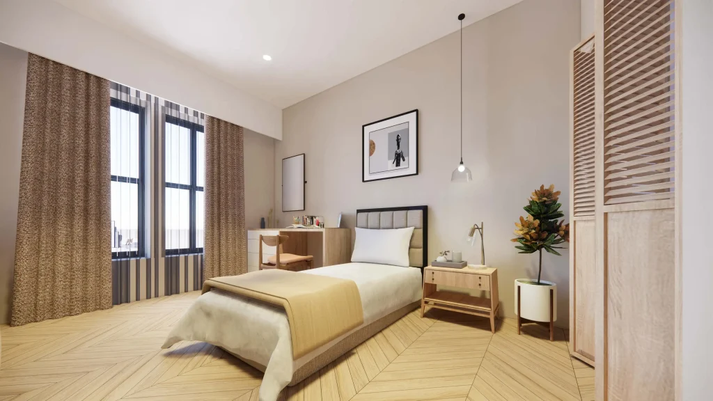 Minimalist bedroom with beige and white tones, featuring a bed, desk, and pendant light.